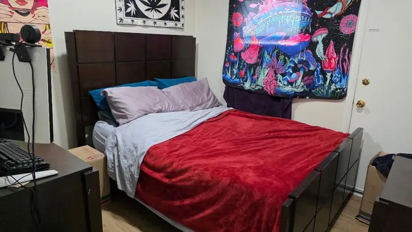 a bed sitting in a bedroom next to a lamp