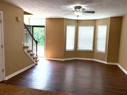 a view of an empty room with a window and wooden floor