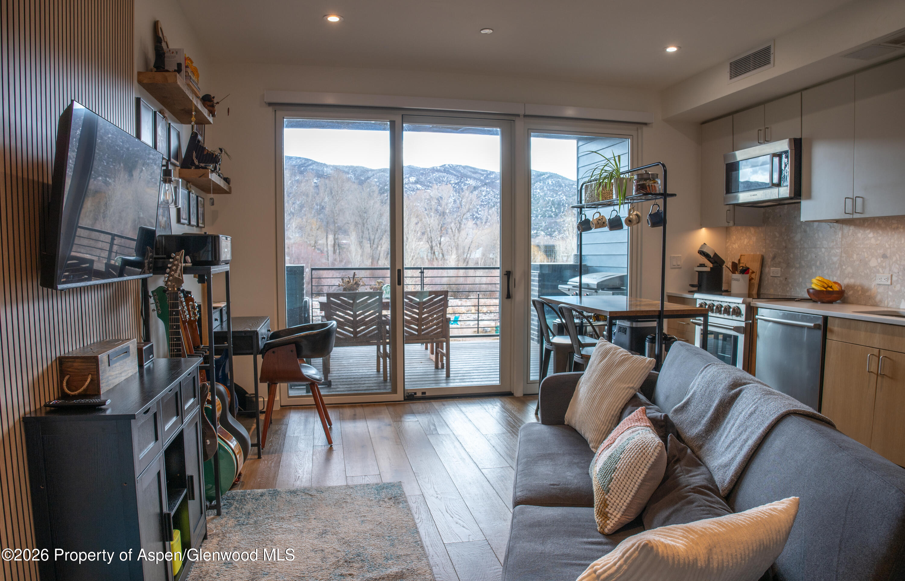 22860 2 Rivers Road, Unit 274 Basalt, CO 81621 - Photo 7 of 13 a living room with furniture a flat screen tv and a floor to ceiling window