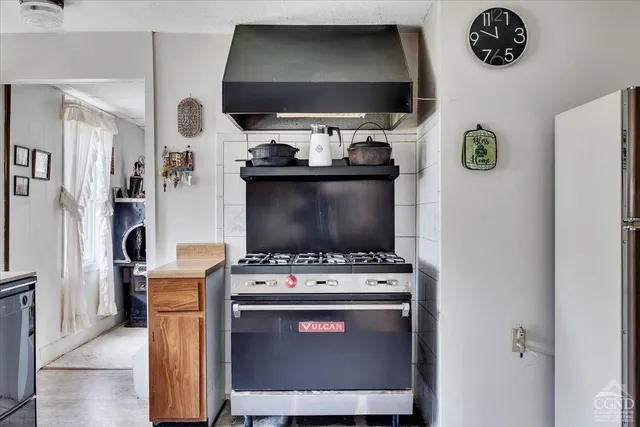 a kitchen with stainless steel appliances a stove a refrigerator and a dining table