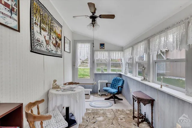 a bedroom with furniture and a large window