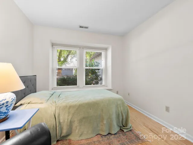 a bed sitting in a bedroom next to a window