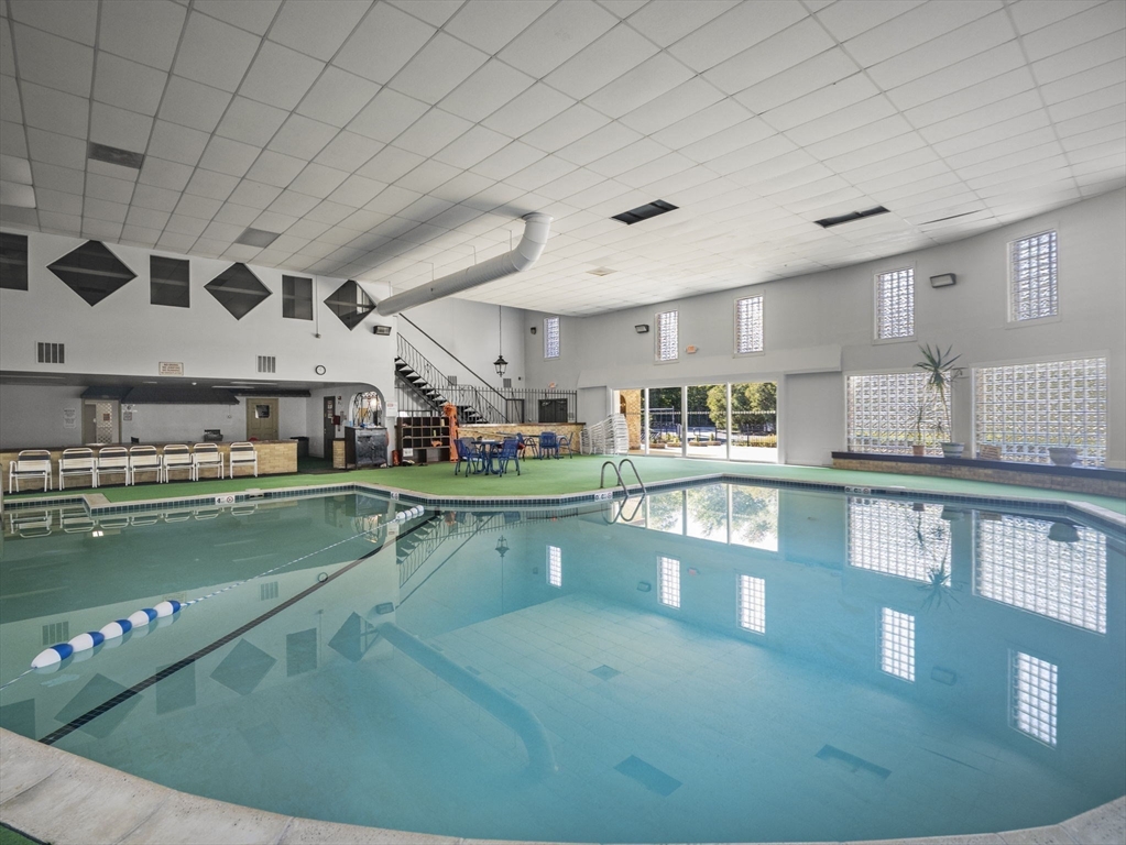 7 Shadowbrook Lane, Unit 9 Milford, MA 01757 - Photo 30 of 41 a living room with lots of wooden furniture and a kitchen view