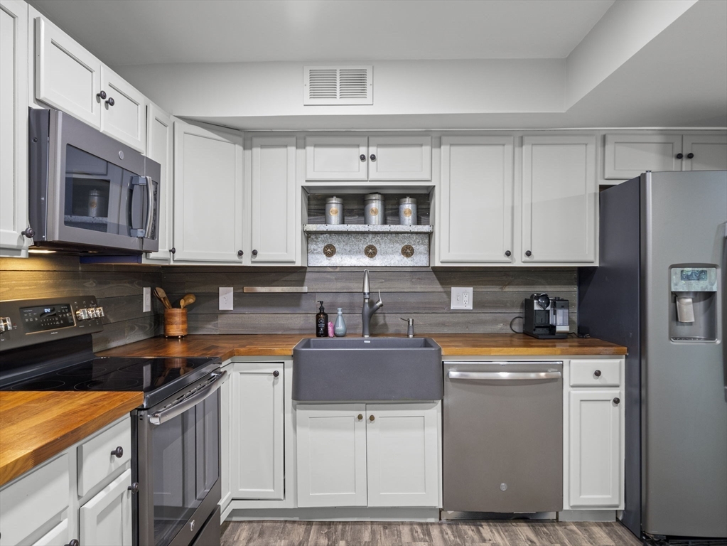 7 Shadowbrook Lane, Unit 9 Milford, MA 01757 - Photo 4 of 41 a kitchen with stainless steel appliances a sink stove and cabinets