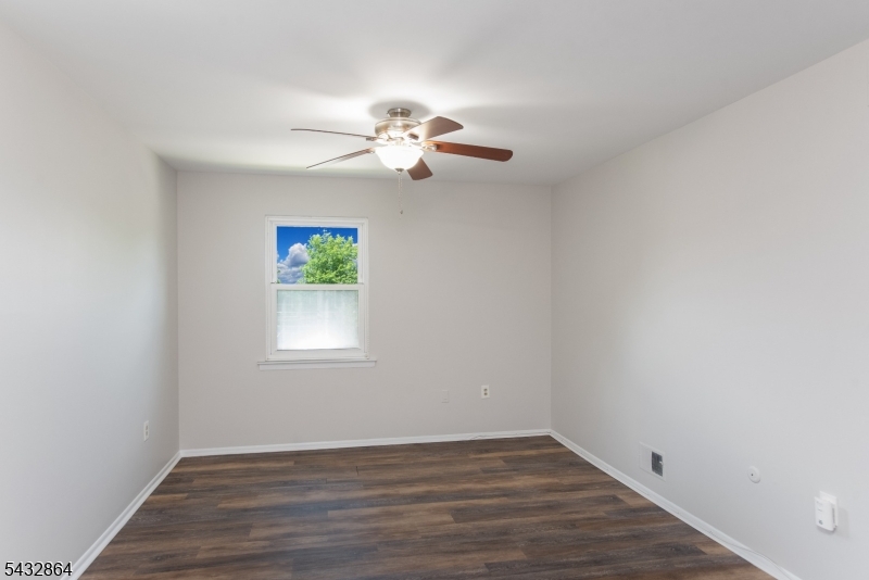 504 Nottingham Way, Unit 504 Flemington, NJ 08822 - Photo 3 of 12 an empty room with wooden floor chandelier fan and windows