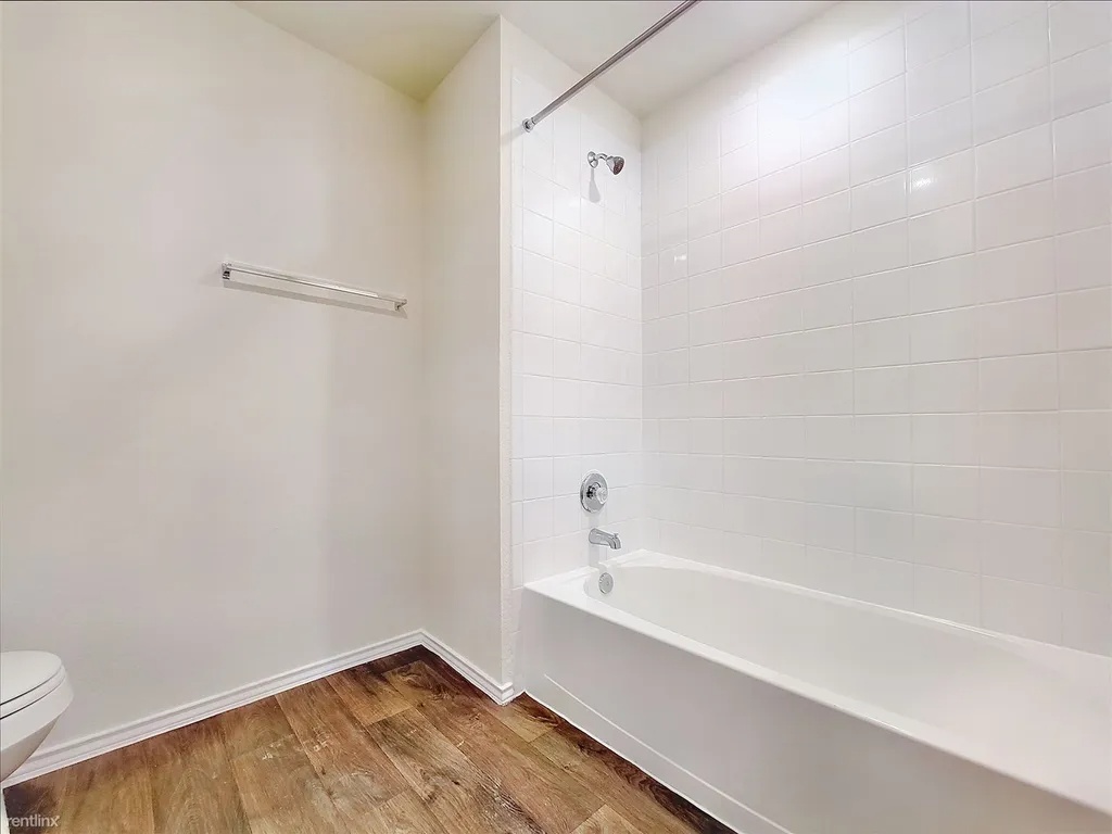 419 Sickle Loop Kyle, TX 78640 - Photo 29 of 35 Functional bathroom features a clean tub and shower combination with warm-toned flooring.