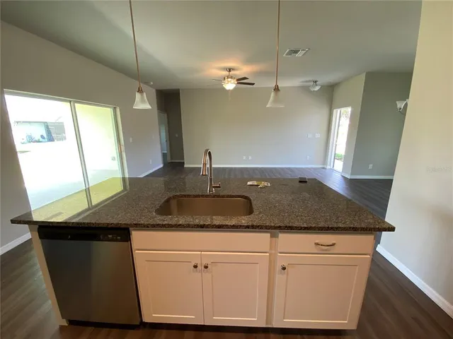 a kitchen with a sink dishwasher and white cabinets