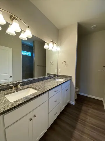 a bathroom with double vanity sink and a mirror