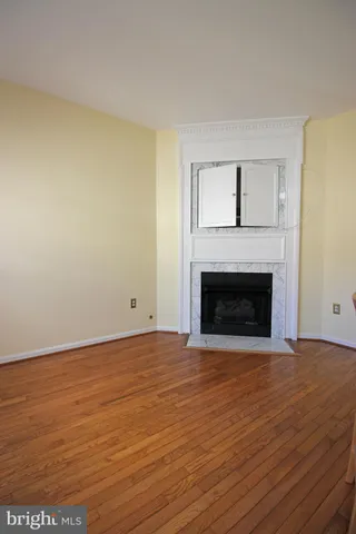 a view of empty room with wooden floor and fireplace