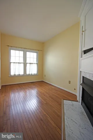 an empty room with wooden floor and fireplace