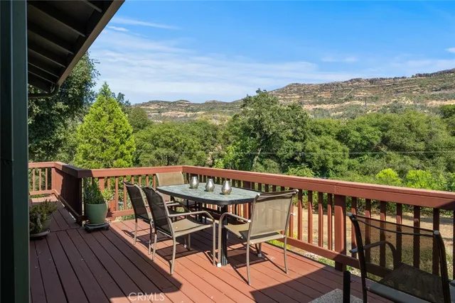 a view of deck with table and chairs under an umbrella with wooden floor