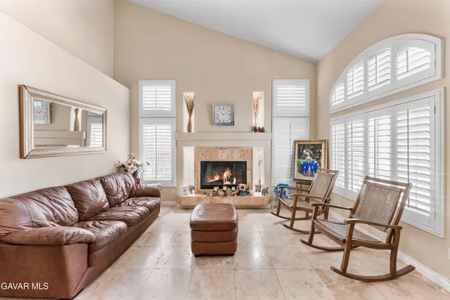 a living room with furniture a large window and a fireplace