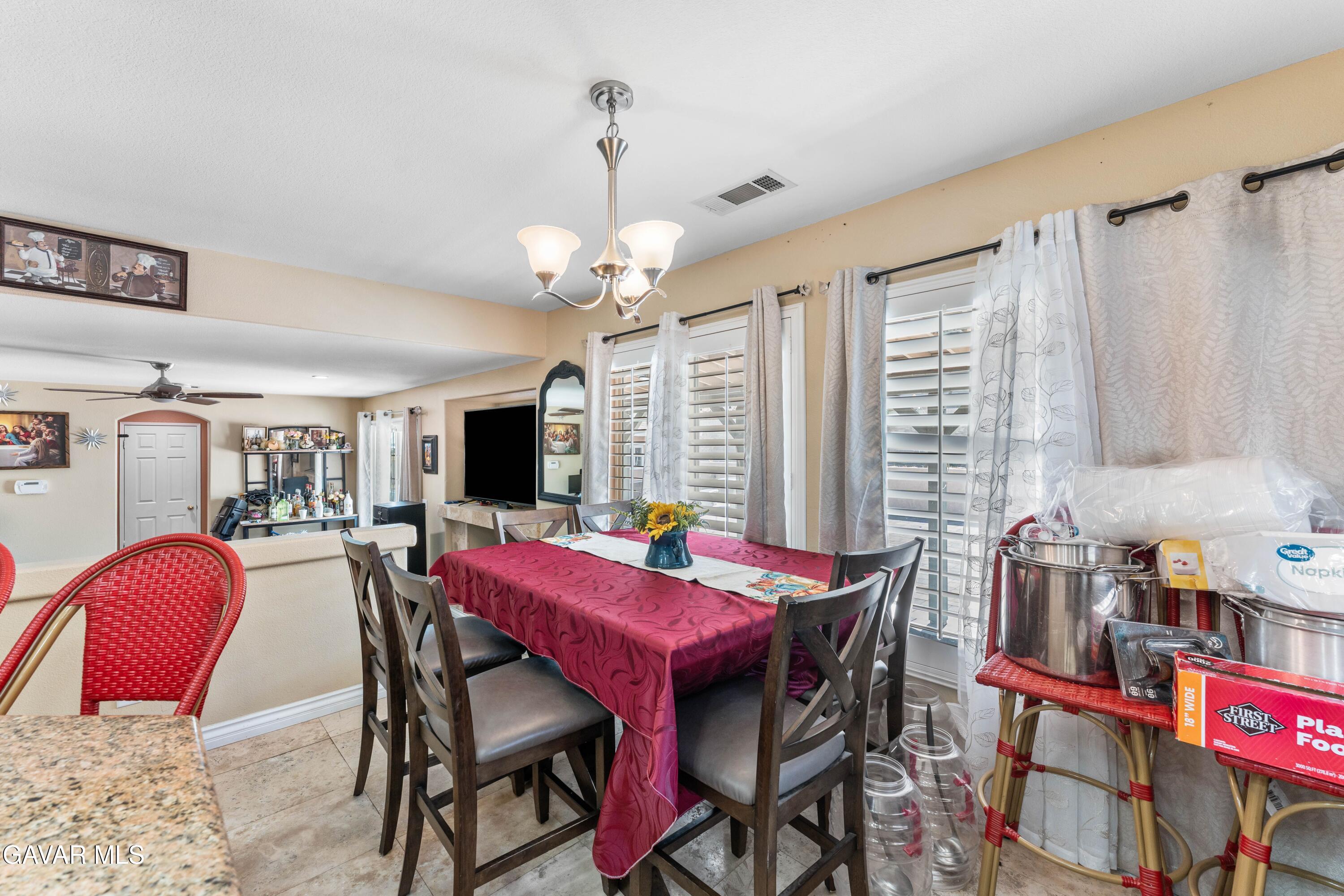 5602 East Ave R 11 Palmdale, CA 93552 - Photo 14 of 27 a view of a dining room with furniture and chandelier