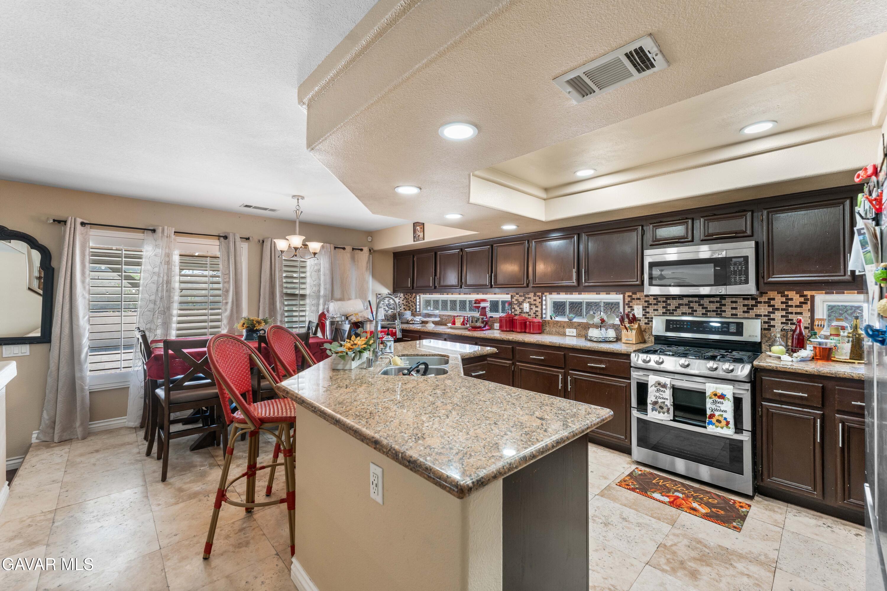 5602 East Ave R 11 Palmdale, CA 93552 - Photo 15 of 27 a kitchen with stainless steel appliances granite countertop a stove and a refrigerator