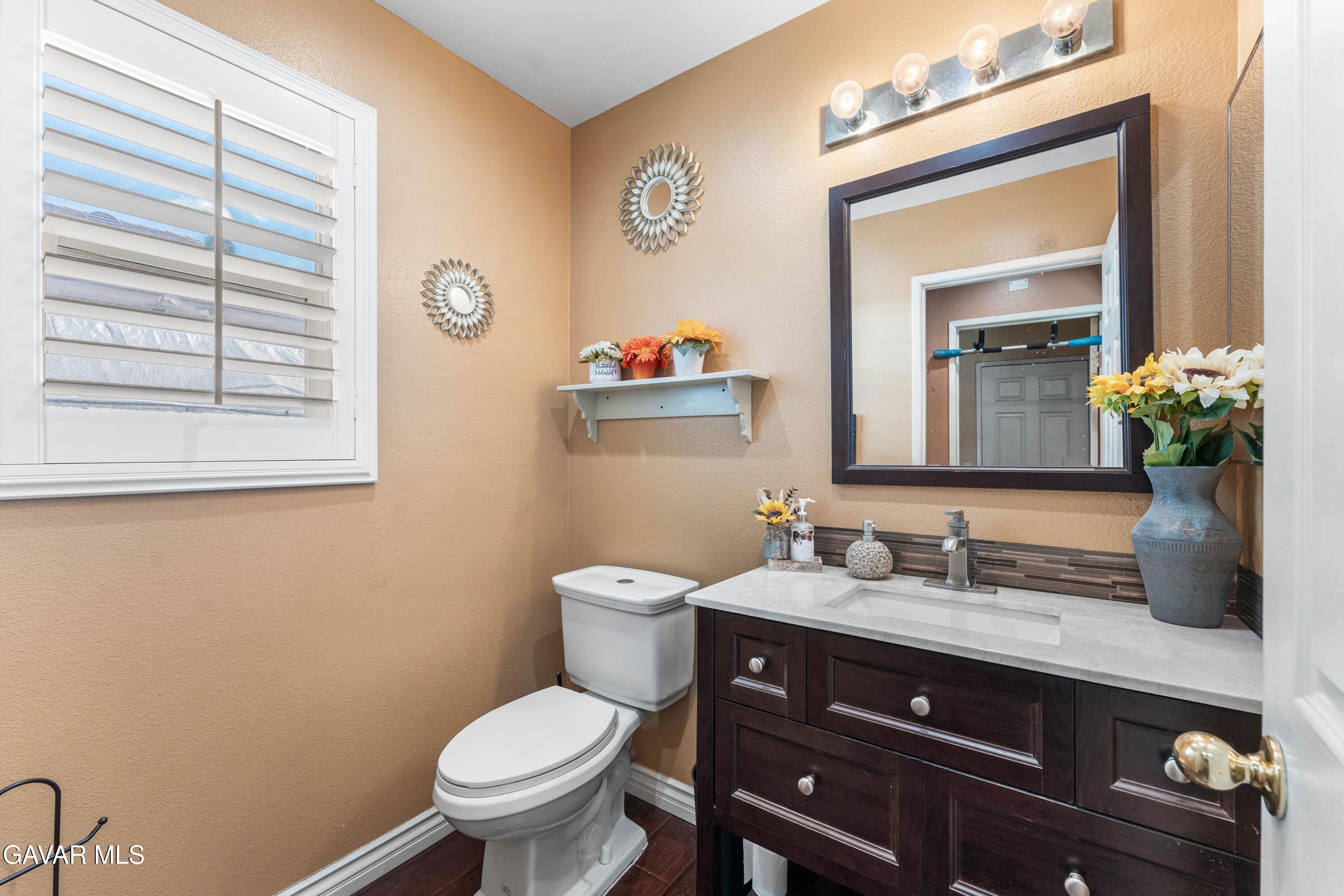 5602 East Ave R 11 Palmdale, CA 93552 - Photo 20 of 27 a bathroom with a toilet a sink and mirror