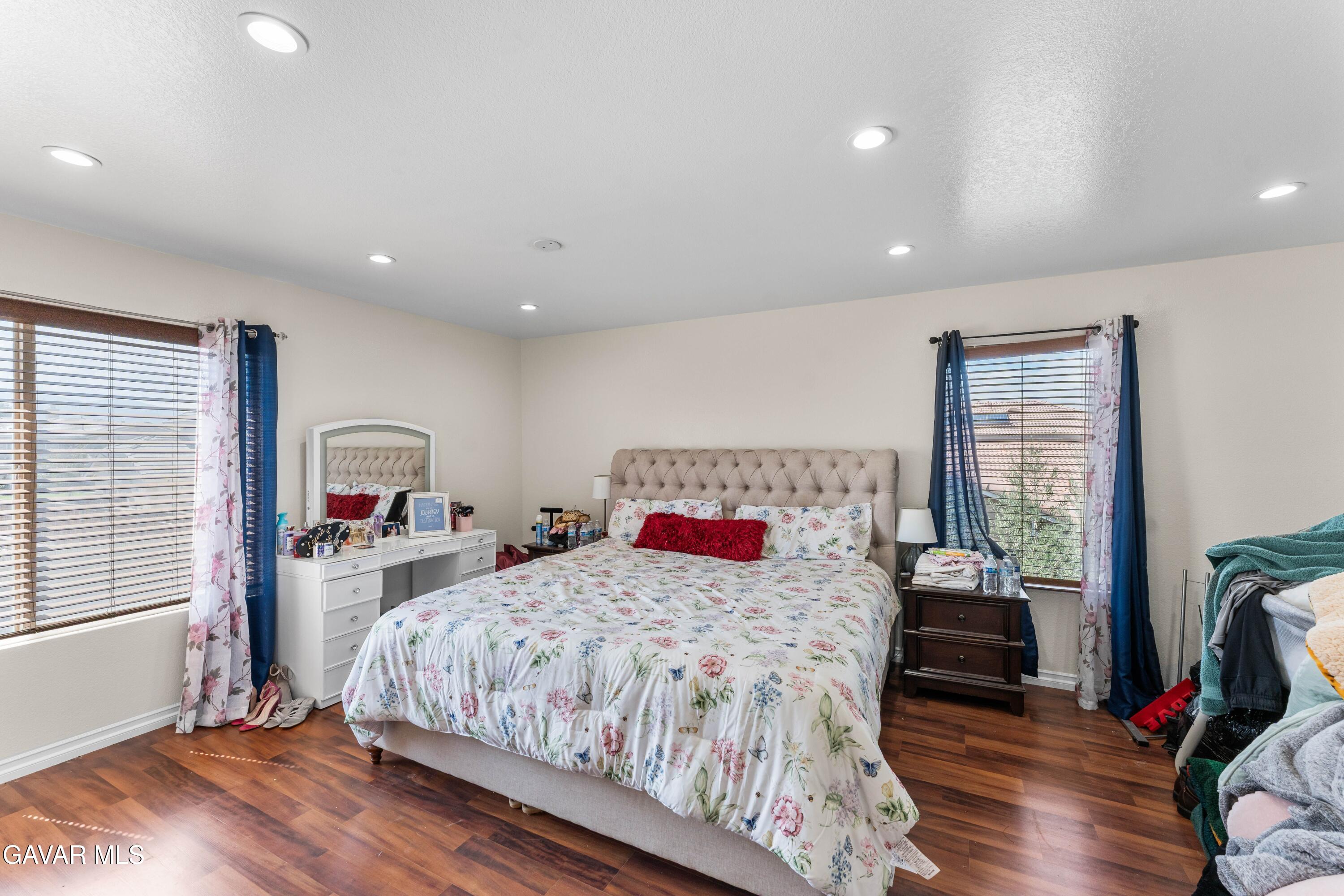 5602 East Ave R 11 Palmdale, CA 93552 - Photo 21 of 27 a bedroom with a bed and wooden floor