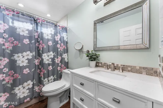 a bathroom with a sink vanity mirror and toilet