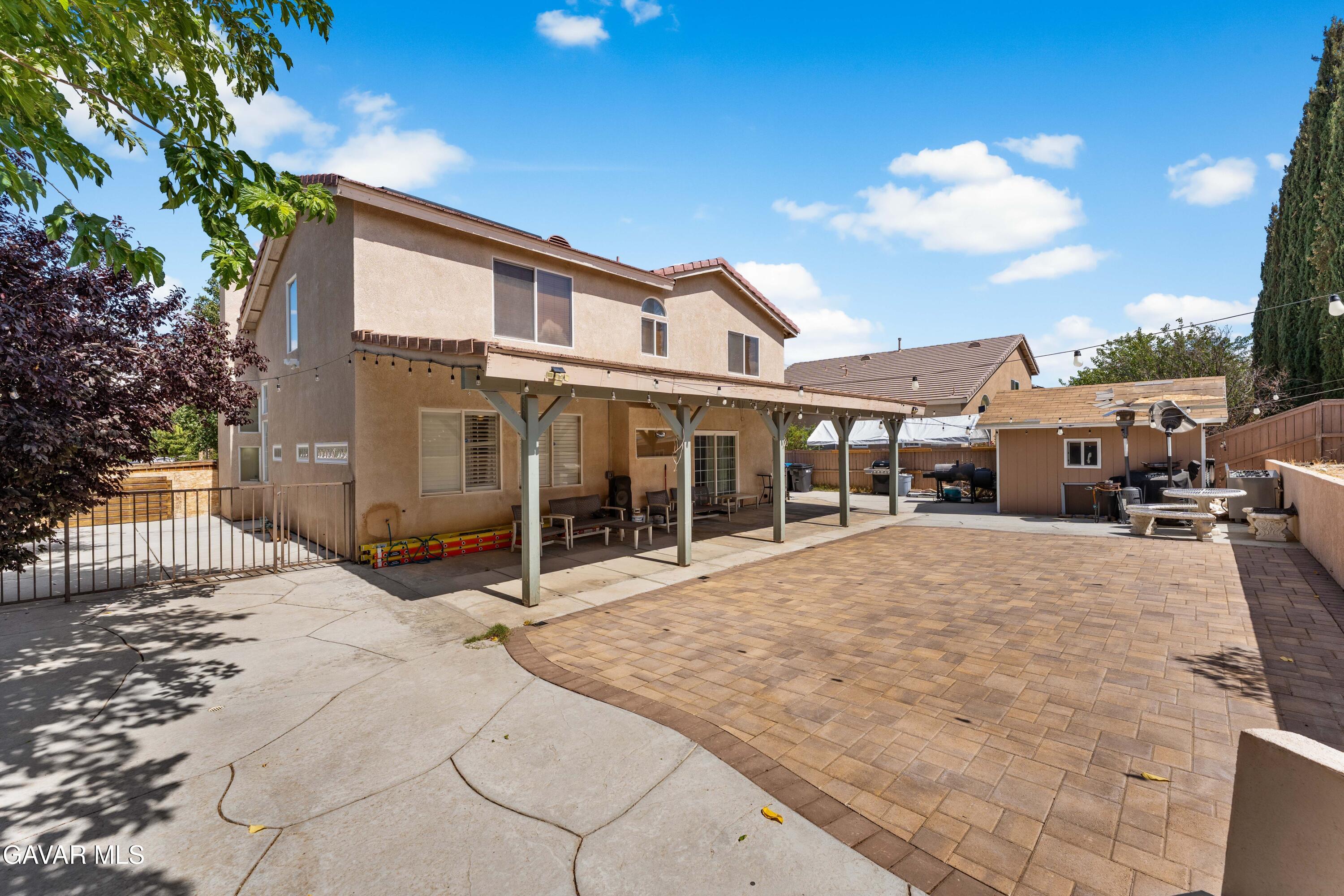 5602 East Ave R 11 Palmdale, CA 93552 - Photo 25 of 27 a patio with a table and chairs and potted plants