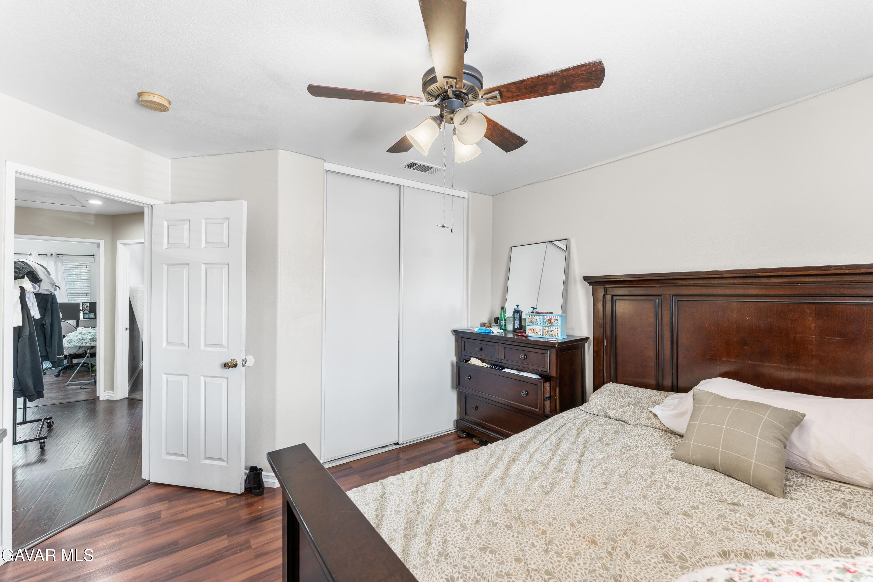 5602 East Ave R 11 Palmdale, CA 93552 - Photo 27 of 27 a bedroom with a bed and wooden floor