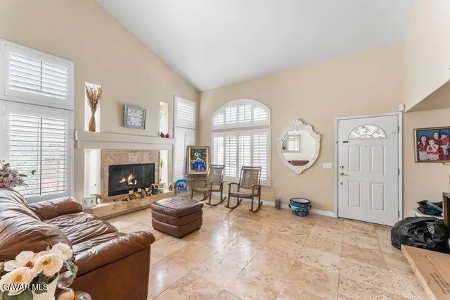 a living room with furniture a fireplace and a large window
