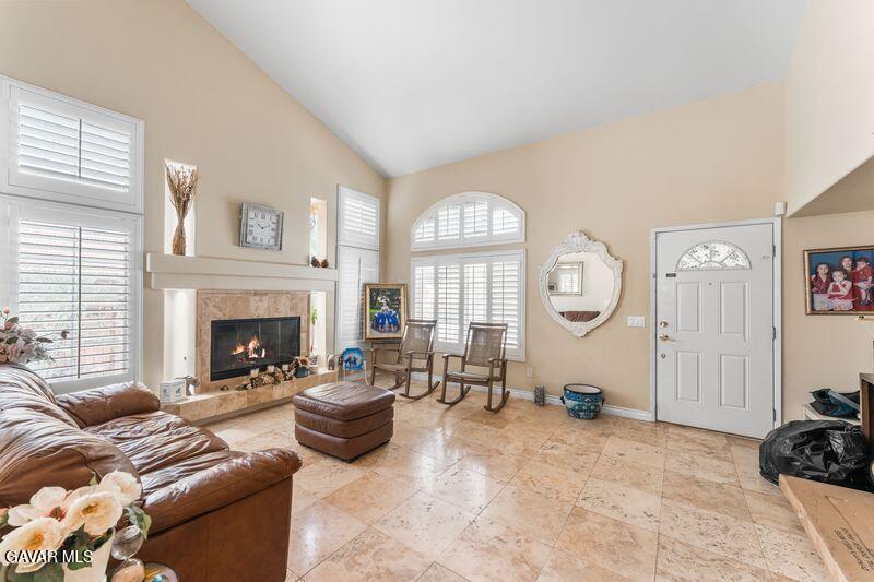 5602 East Ave R 11 Palmdale, CA 93552 - Photo 4 of 27 a living room with furniture a fireplace and a large window
