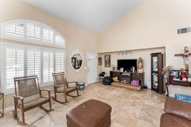 a living room with furniture a flat screen tv and a large window