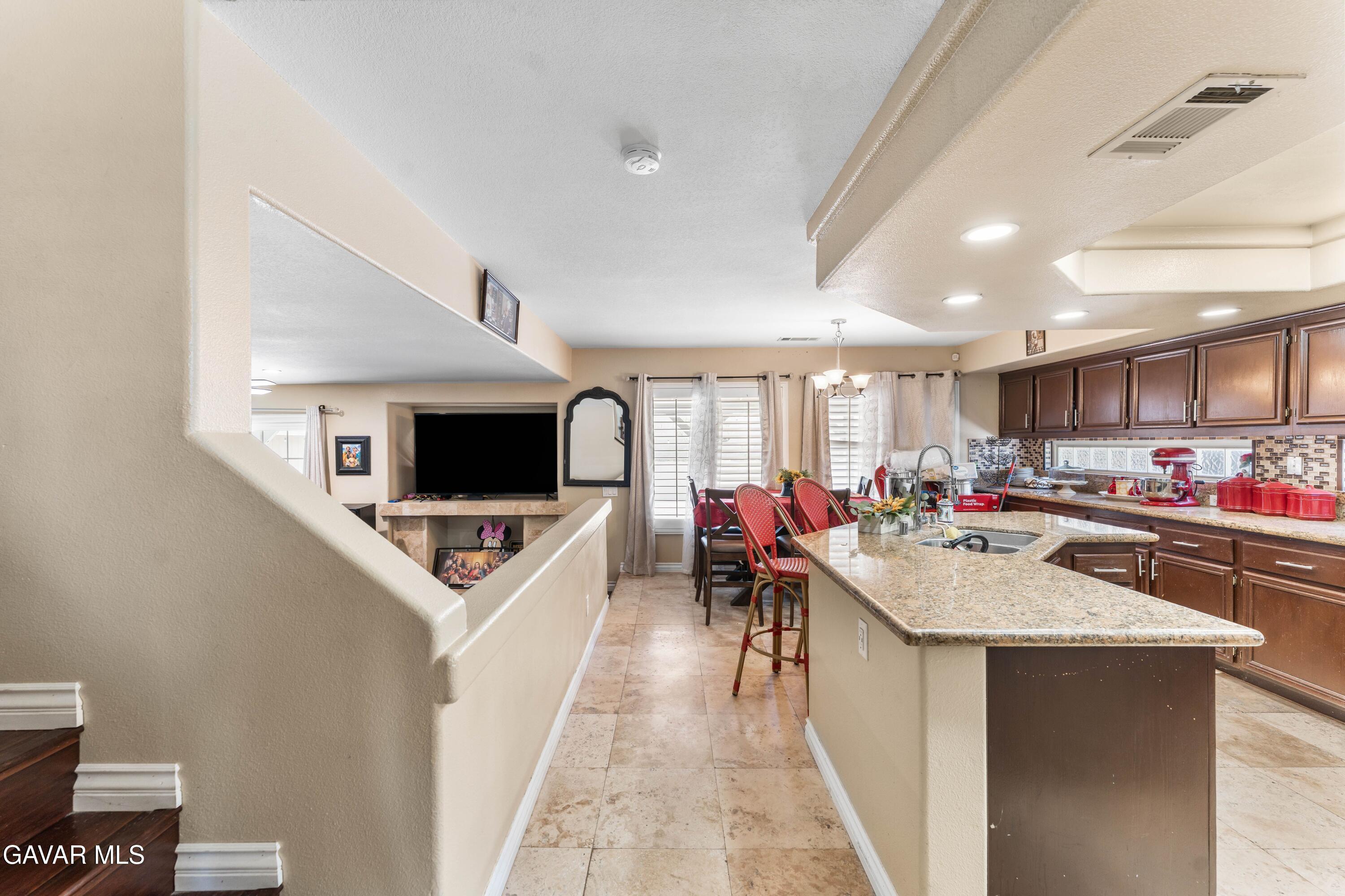 5602 East Ave R 11 Palmdale, CA 93552 - Photo 10 of 27 a living room with stainless steel appliances furniture and a flat screen tv