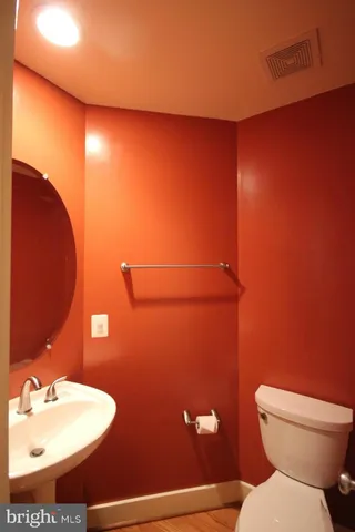 a bathroom with a toilet sink and mirror