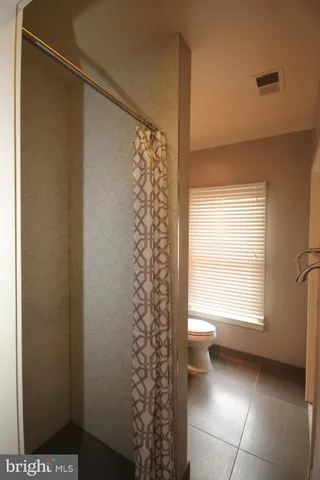 a bathroom with a toilet and a shower curtain