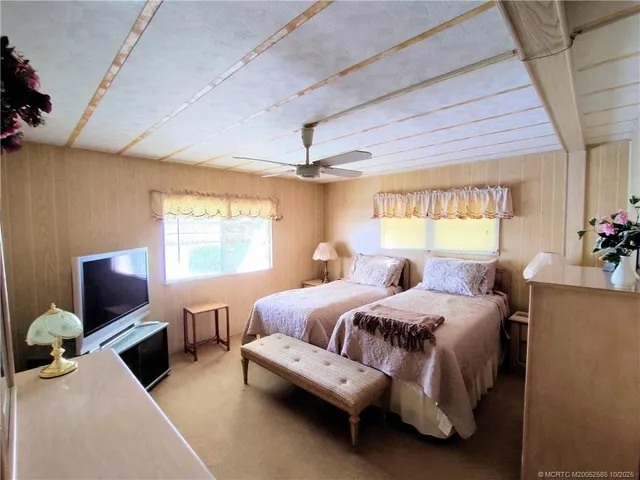 a bedroom with furniture a flat screen tv and a window