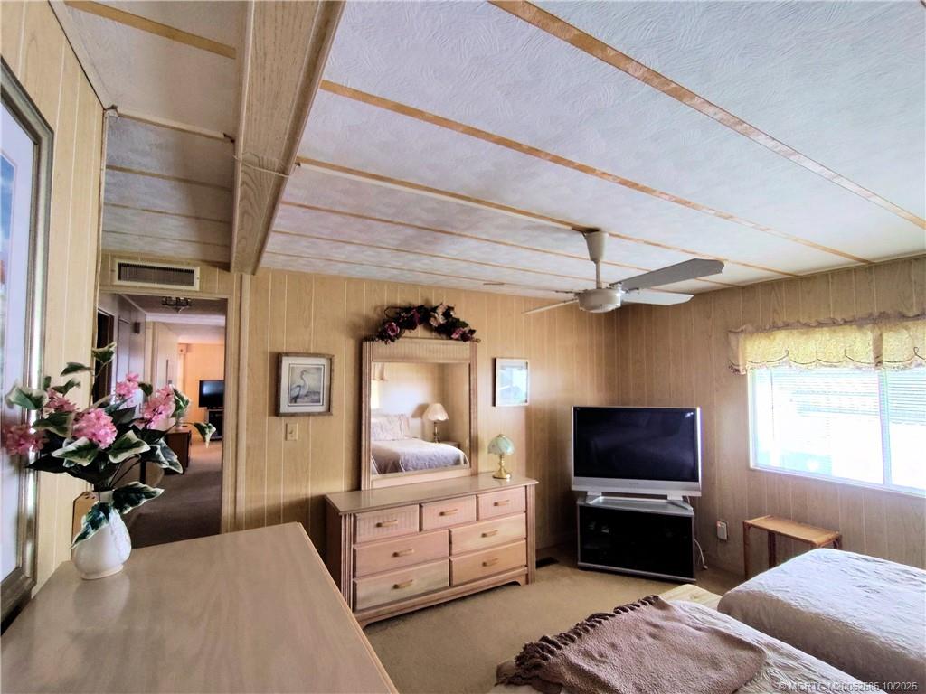 2540 Southeast Penny Lane Stuart, FL 34994 - Photo 24 of 62 a bedroom with furniture a flat screen tv and a window