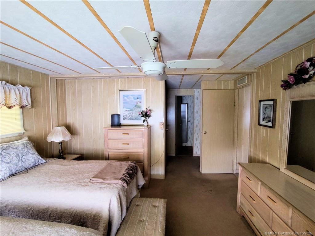 2540 Southeast Penny Lane Stuart, FL 34994 - Photo 26 of 62 a bedroom with a bed and a chandelier