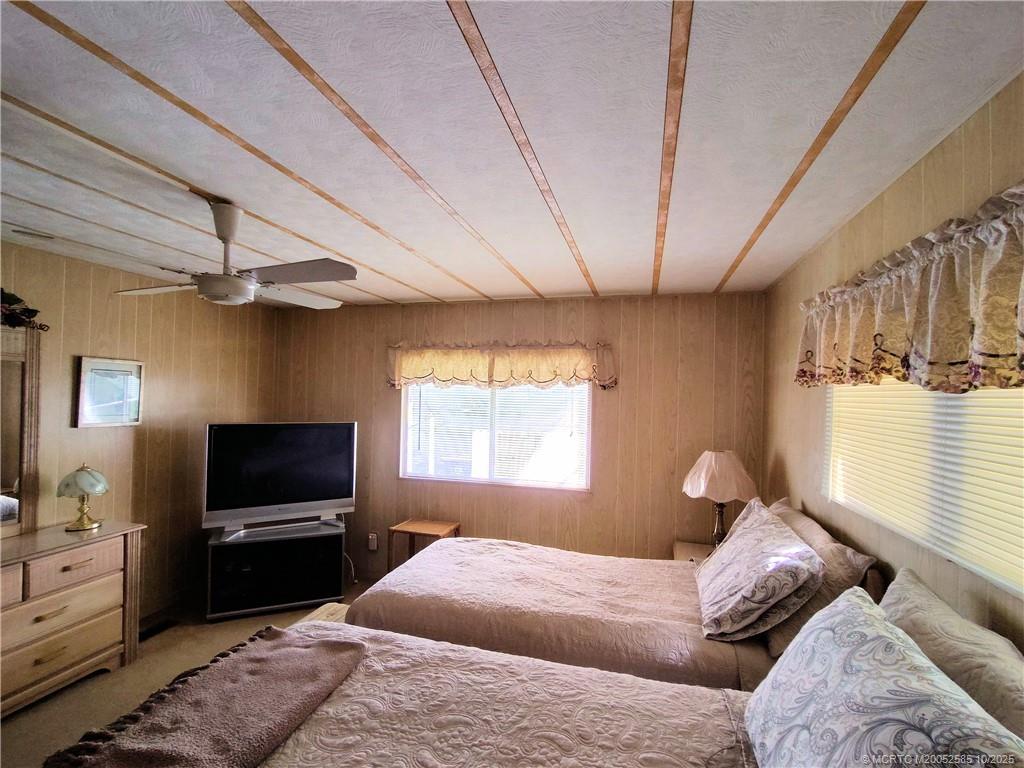 2540 Southeast Penny Lane Stuart, FL 34994 - Photo 27 of 62 a bedroom with a bed and a flat screen tv
