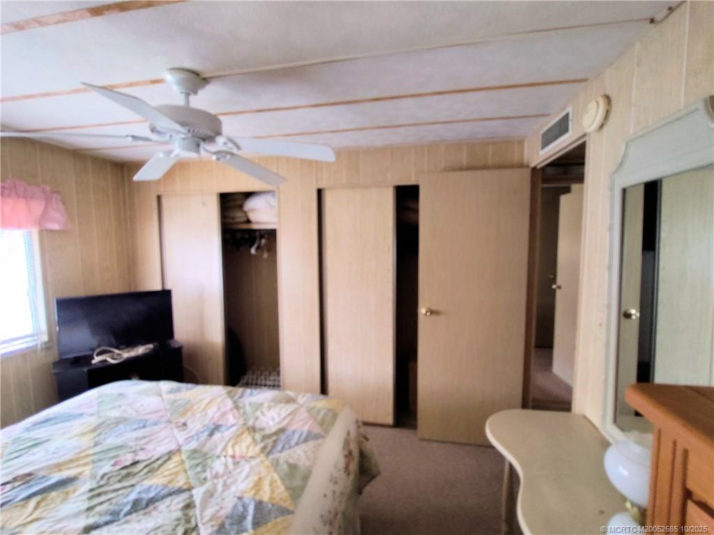 2540 Southeast Penny Lane Stuart, FL 34994 - Photo 35 of 62 a bedroom with a bed and a chandelier