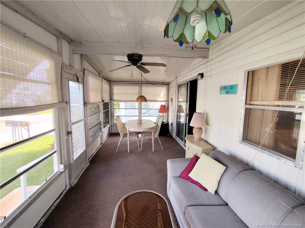 2540 Southeast Penny Lane Stuart, FL 34994 - Photo 38 of 62 a living room with furniture a rug and a chandelier