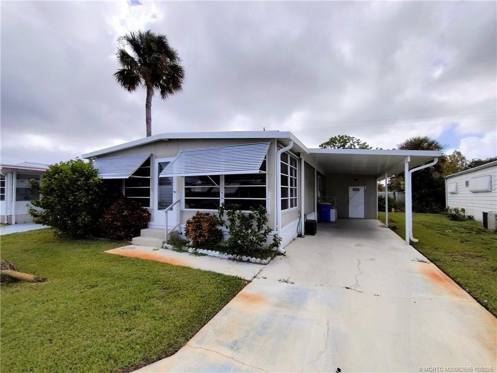 2540 Southeast Penny Lane Stuart, FL 34994 - Photo 45 of 62 a front view of a house with a yard and garage