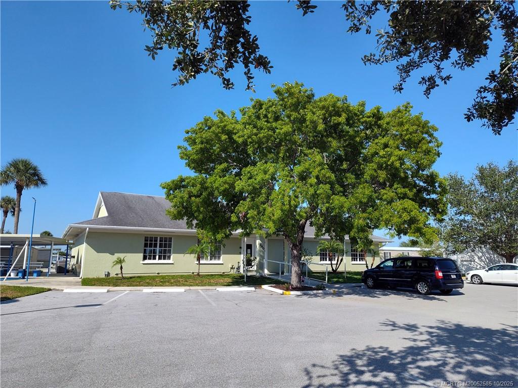 2540 Southeast Penny Lane Stuart, FL 34994 - Photo 47 of 62 a front view of a house with a garden and parking