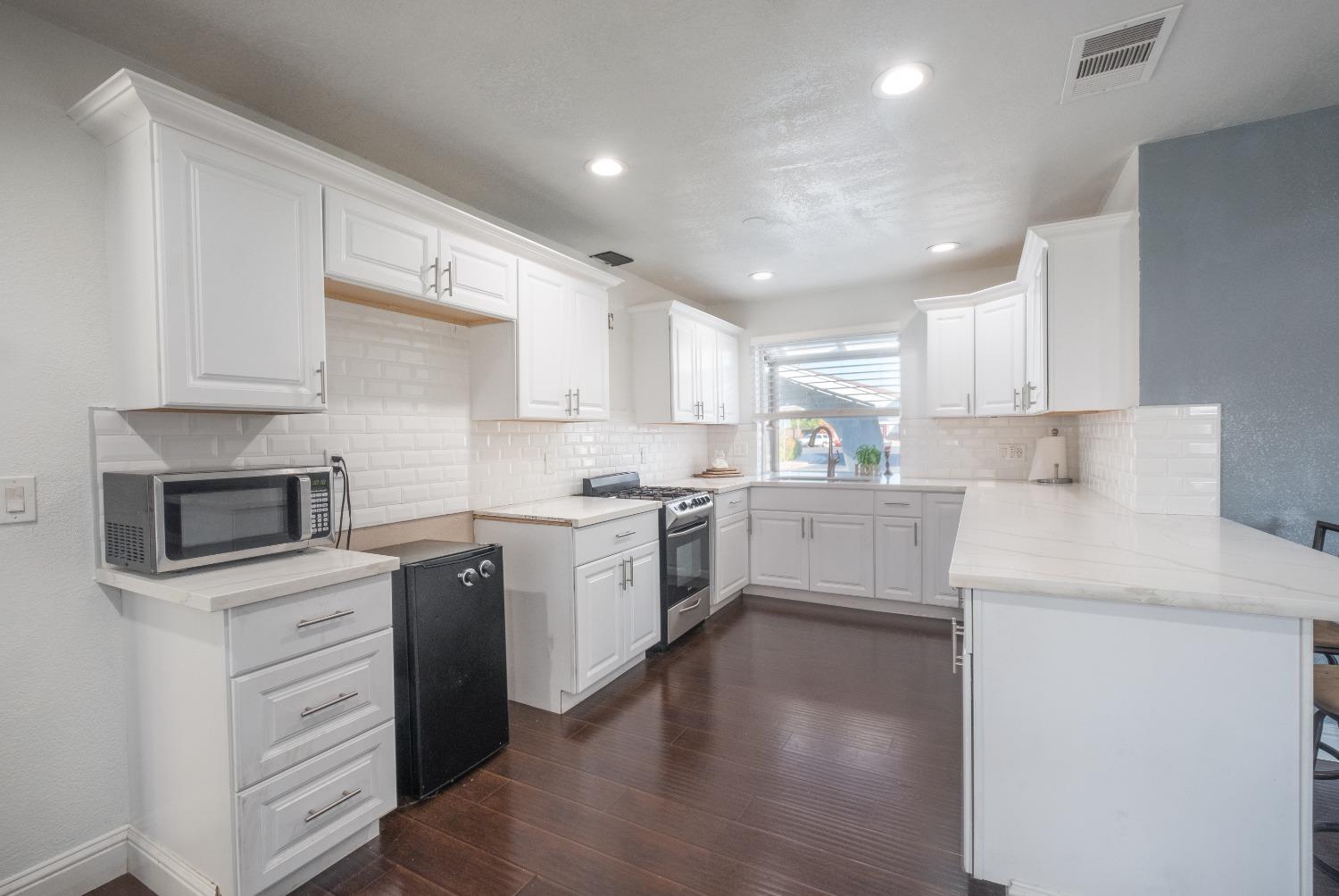 172 West Swift Avenue Clovis, CA 93612 - Photo 6 of 22 a kitchen with granite countertop white cabinets and white appliances
