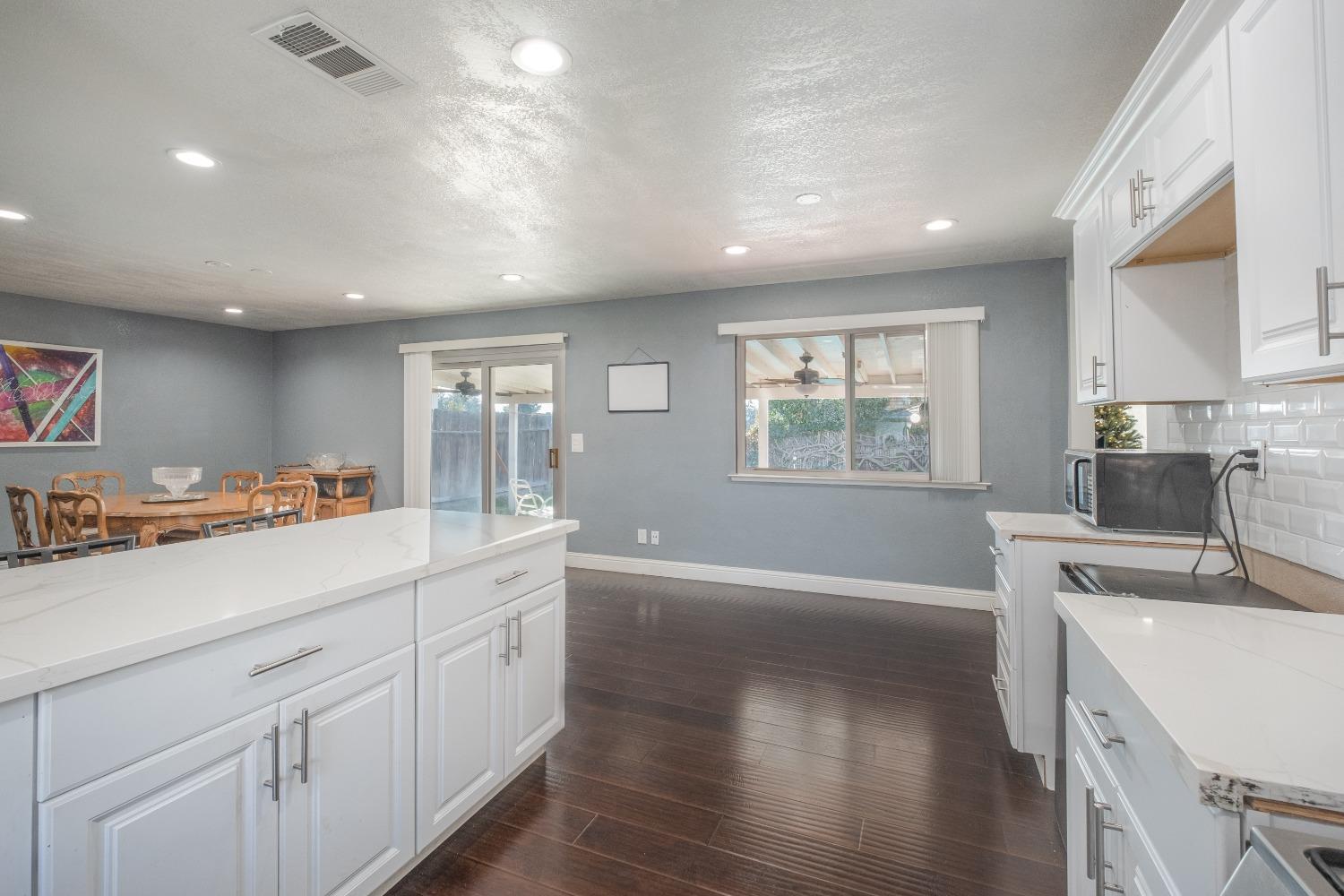 172 West Swift Avenue Clovis, CA 93612 - Photo 7 of 22 a open kitchen with kitchen island a sink appliances cabinets and a large window