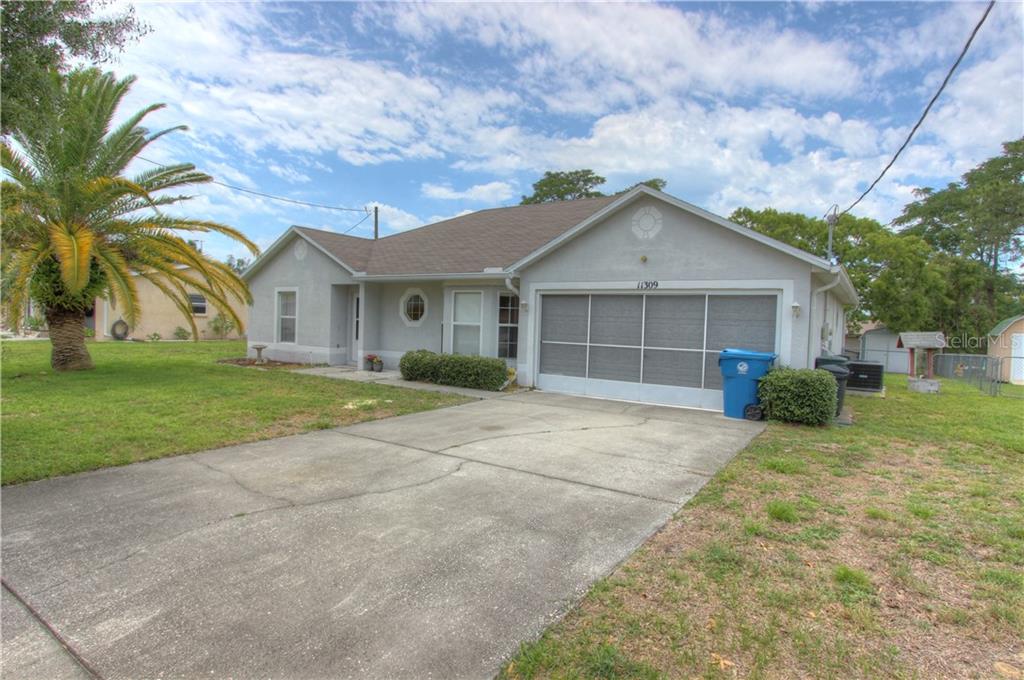 11309 Montcalm Road Spring Hill, FL 34608 - Photo 1 of 1 a front view of a house with a yard and garage