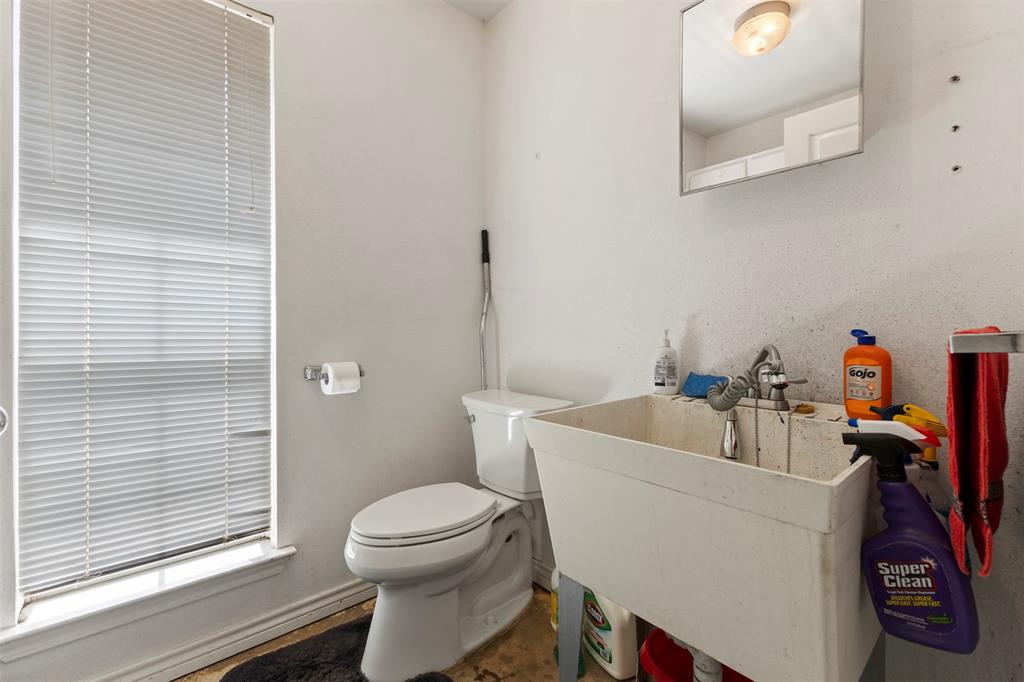 401 Rugged Drive Red Oak, TX 75154 - Photo 27 of 40 Utility room featuring a window with horizontal blinds, a toilet, a wall-mounted paper holder, a utility sink with faucet, and a wall-mounted mirror
