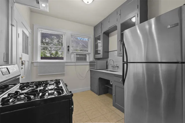 a kitchen with a stove a refrigerator and a window
