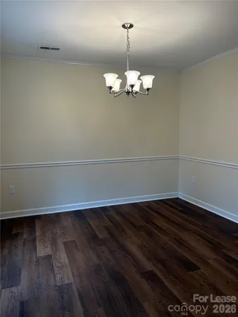 a view of wooden floor and a chandelier in a room