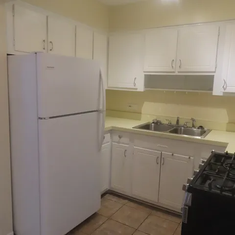 a kitchen with granite countertop white cabinets and stainless steel appliances