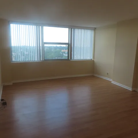 a view of an empty room with wooden floor
