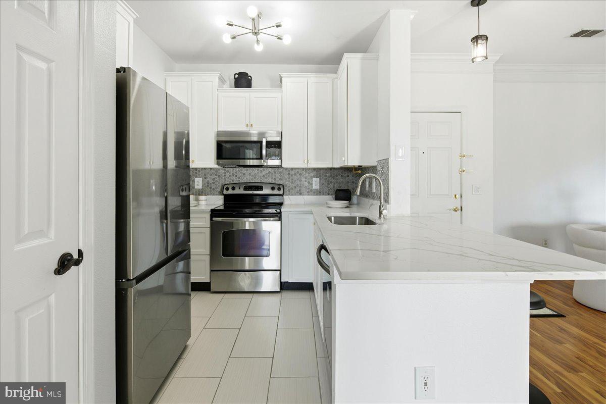 1591 Spring Gate Dr., Unit 3406 McLean, VA 22102 - Photo 20 of 45 a kitchen with stainless steel appliances a refrigerator sink and white cabinets