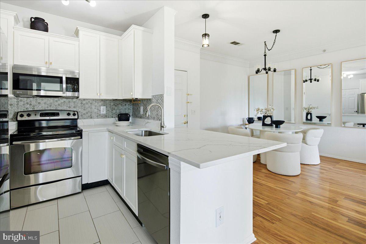 1591 Spring Gate Dr., Unit 3406 McLean, VA 22102 - Photo 21 of 45 a kitchen with a sink stove and cabinets