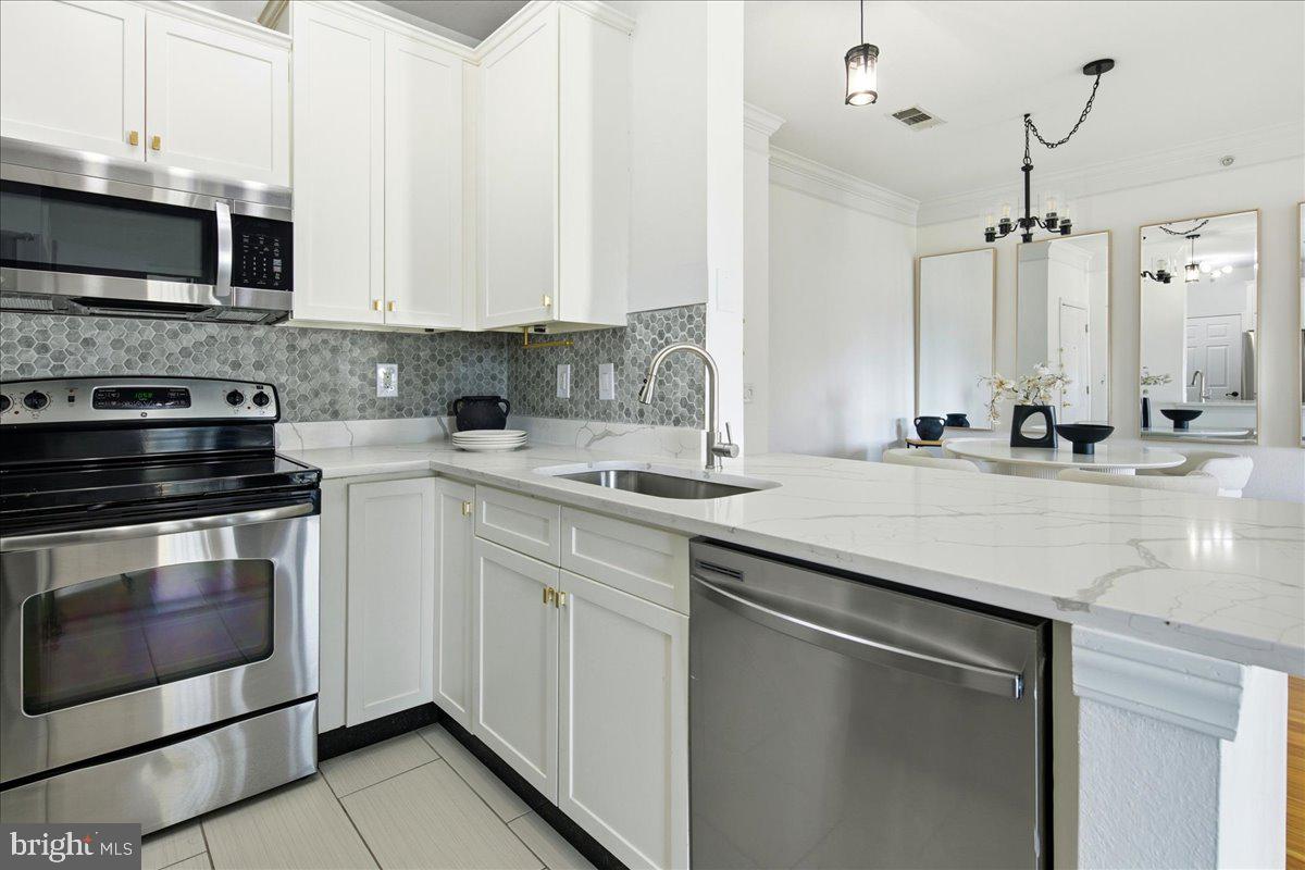 1591 Spring Gate Dr., Unit 3406 McLean, VA 22102 - Photo 22 of 45 a kitchen with stainless steel appliances granite countertop a sink stove and microwave