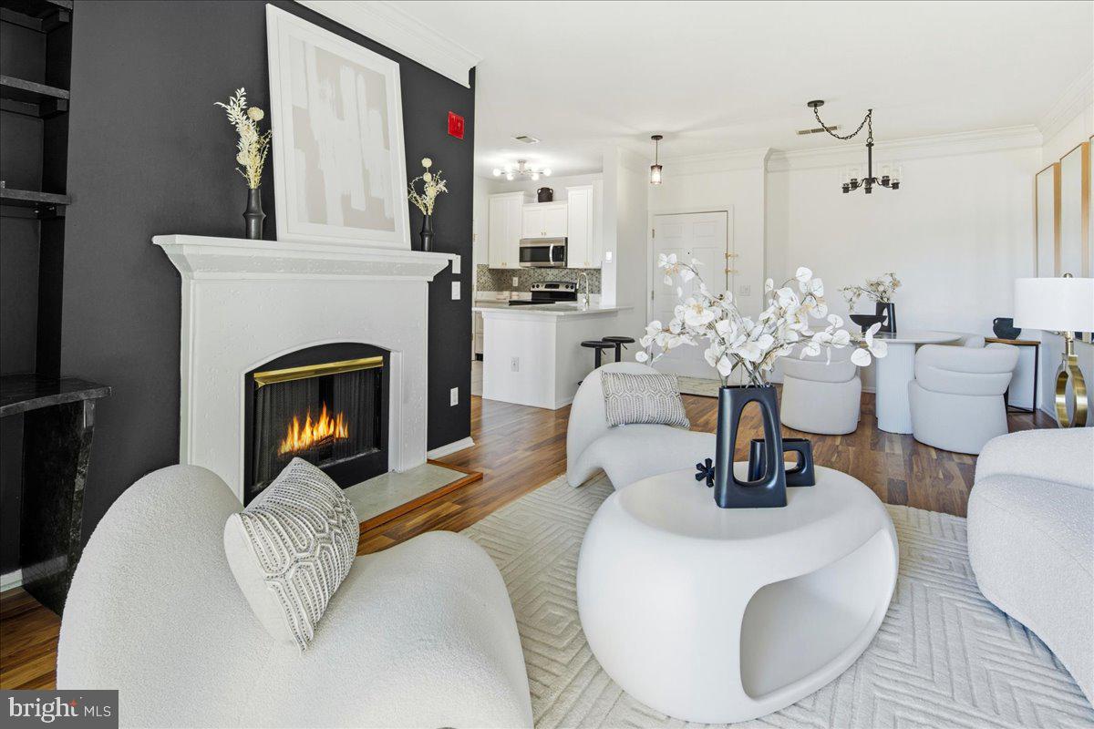 1591 Spring Gate Dr., Unit 3406 McLean, VA 22102 - Photo 10 of 45 a living room with furniture a fireplace and a chandelier