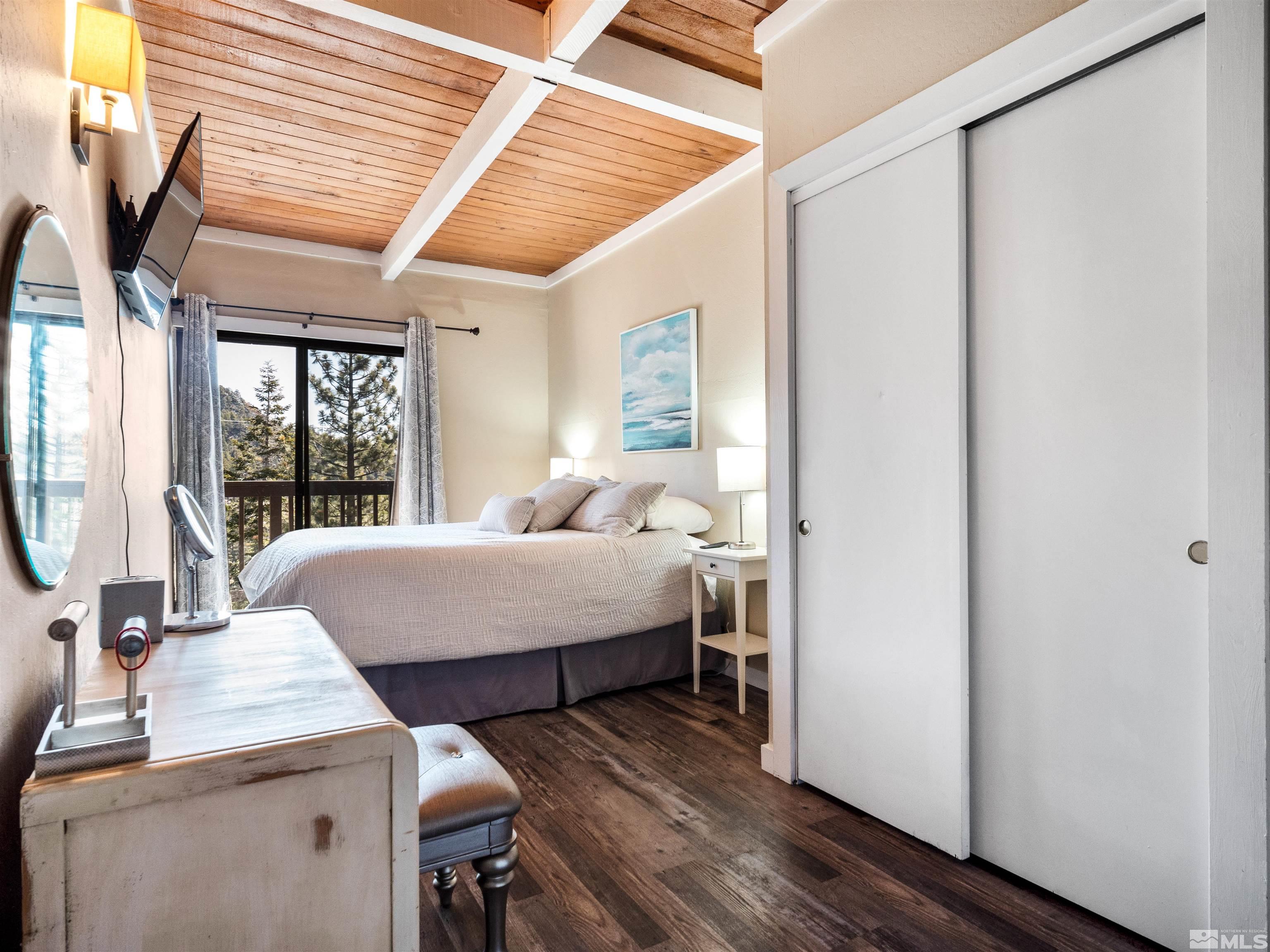 111 Tramway Drive, Unit 2 Stateline, NV 89449 - Photo 13 of 37 a bedroom with a bed and large windows